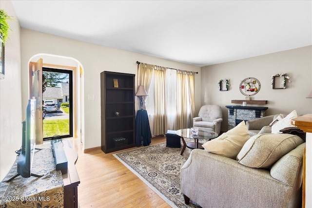 living area featuring light wood-type flooring, plenty of natural light, and baseboards