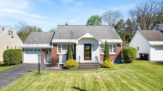 view of front of home with brick siding, an attached garage, driveway, a front lawn, and a chimney