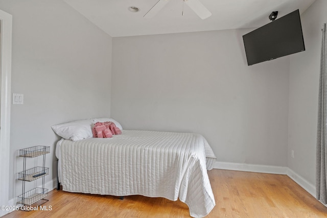 bedroom with wood finished floors, baseboards, and a ceiling fan
