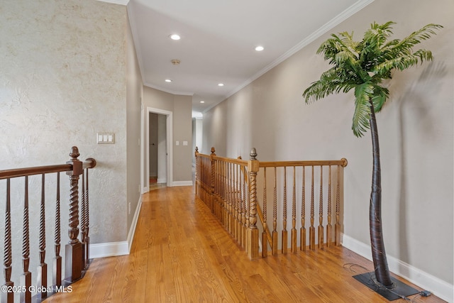 hall featuring an upstairs landing, crown molding, wood finished floors, recessed lighting, and baseboards