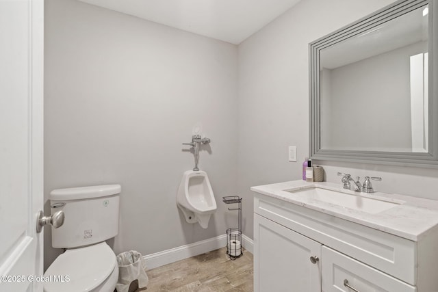 half bath featuring wood finished floors, toilet, baseboards, and vanity