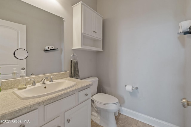 bathroom with tile patterned flooring, toilet, vanity, and baseboards