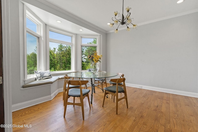 dining room featuring ornamental molding, breakfast area, baseboards, light wood finished floors, and a chandelier