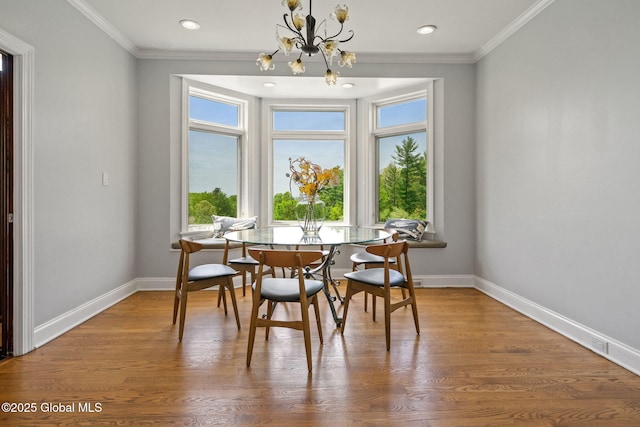 dining room featuring a chandelier, baseboards, ornamental molding, wood finished floors, and recessed lighting
