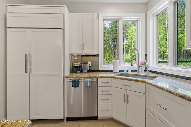 kitchen with dishwasher, a sink, healthy amount of natural light, and light stone counters