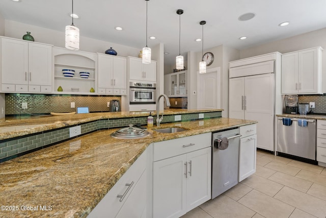 kitchen with stainless steel appliances, a sink, backsplash, white cabinetry, and light tile patterned floors