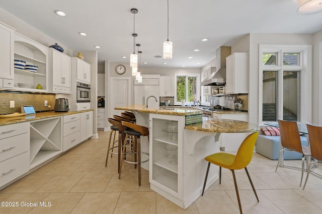 kitchen featuring open shelves, stainless steel oven, a breakfast bar area, tasteful backsplash, and recessed lighting
