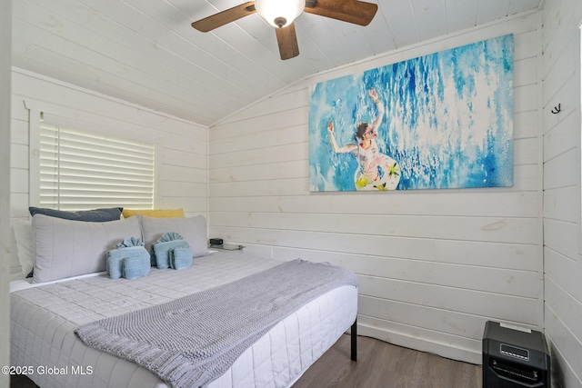 bedroom with lofted ceiling, wood finished floors, wood walls, and a ceiling fan