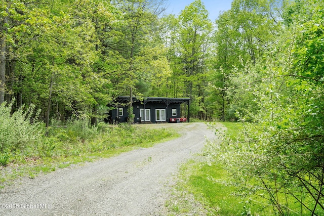 view of dirt / gravel road with a view of trees
