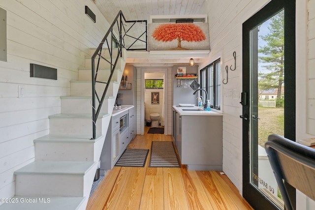 stairway featuring wood finished floors and wooden walls