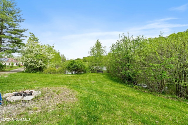 view of grassy yard featuring a fire pit