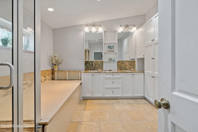 bathroom with stone tile flooring, vanity, tasteful backsplash, and recessed lighting