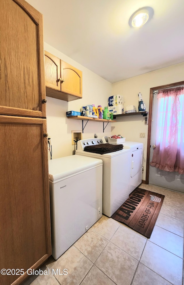 laundry area featuring cabinet space, washer and clothes dryer, and light tile patterned floors