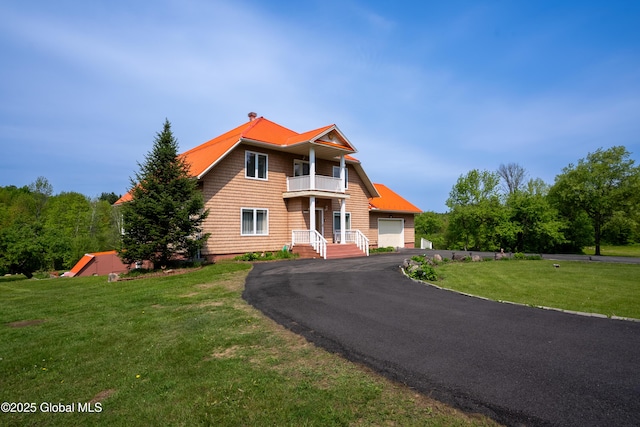 1435 Webster St, Malone, NY 12953 - view of front facade featuring a balcony, a front yard, driveway, and an attached garage