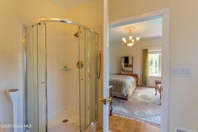 1435 Webster St, Malone, NY 12953 - bathroom featuring crown molding, ensuite bathroom, a stall shower, a chandelier, and wood finished floors