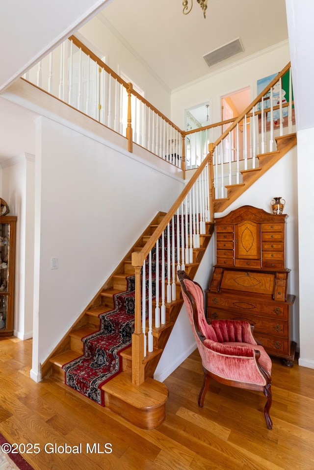 1435 Webster St, Malone, NY 12953 - stairs with wood finished floors, a towering ceiling, and crown molding