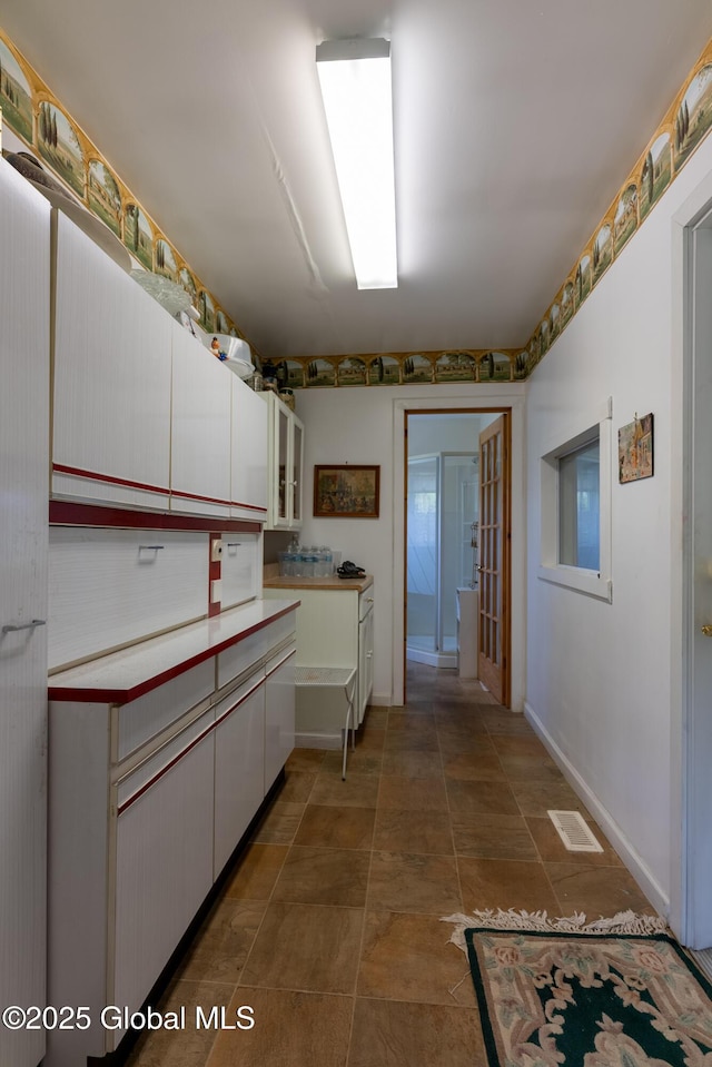 1435 Webster St, Malone, NY 12953 - kitchen with white cabinets, glass insert cabinets, and light countertops