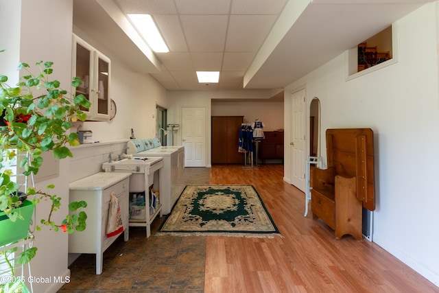 1435 Webster St, Malone, NY 12953 - laundry room featuring washing machine and clothes dryer, arched walkways, and wood finished floors