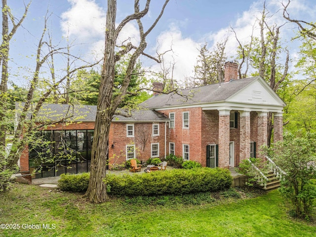 632 Albany Tpke, Chatham, NY 12136 - greek revival house featuring a chimney, brick siding, and a front yard