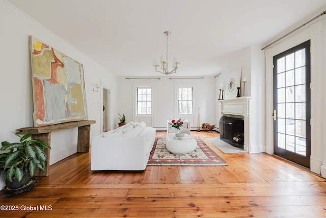 632 Albany Tpke, Chatham, NY 12136 - living room featuring a chandelier, hardwood / wood-style floors, a fireplace with flush hearth, and crown molding
