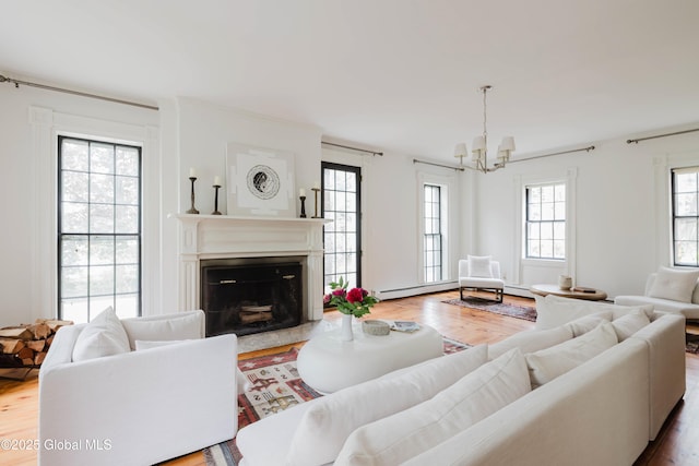 632 Albany Tpke, Chatham, NY 12136 - living area with a chandelier, wood finished floors, a fireplace, and a baseboard heating unit