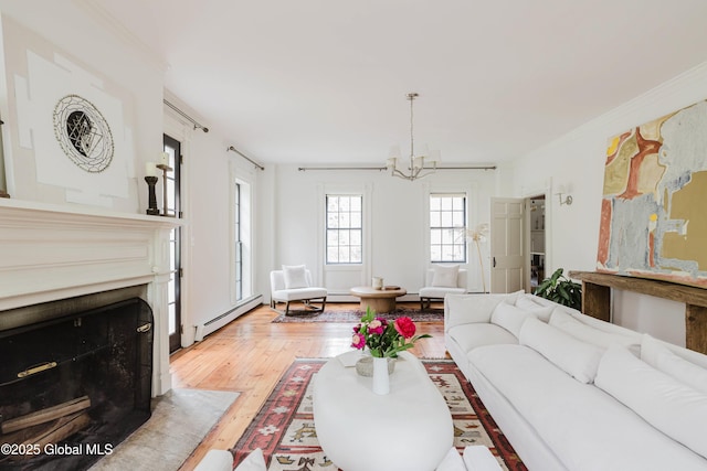 632 Albany Tpke, Chatham, NY 12136 - living area with baseboard heating, a chandelier, a fireplace with flush hearth, light wood-style flooring, and crown molding