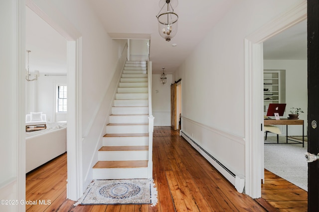 632 Albany Tpke, Chatham, NY 12136 - stairway featuring a baseboard radiator, a chandelier, and hardwood / wood-style floors