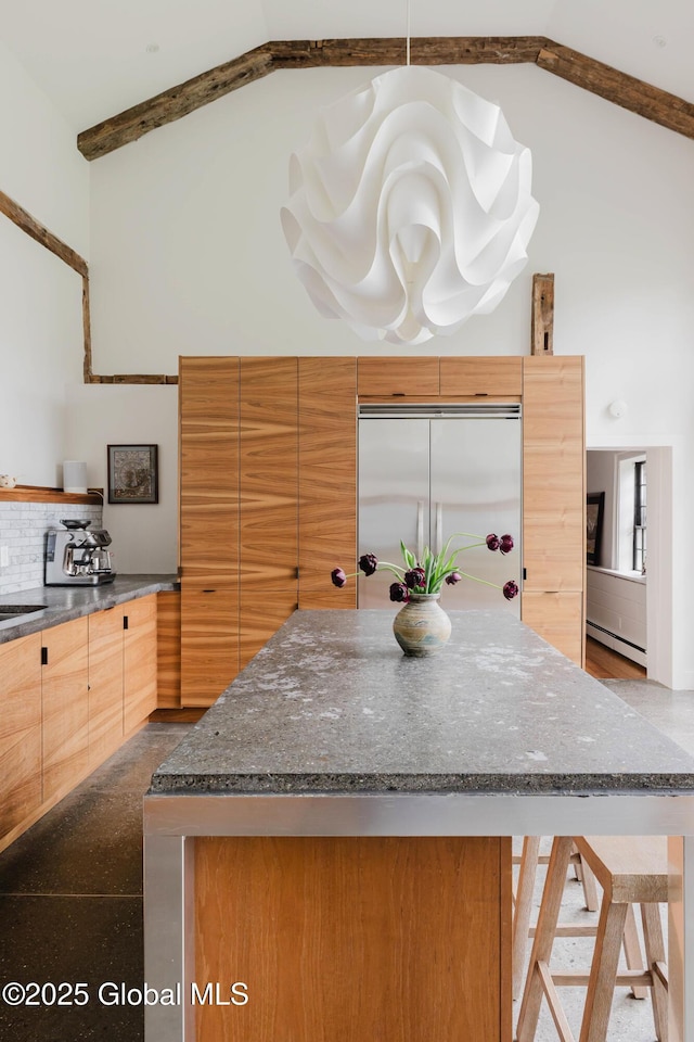632 Albany Tpke, Chatham, NY 12136 - kitchen with built in fridge, a baseboard heating unit, dark stone countertops, a kitchen island, and beamed ceiling