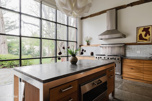 632 Albany Tpke, Chatham, NY 12136 - kitchen featuring wall chimney range hood, high end range, dark countertops, decorative backsplash, and a chandelier