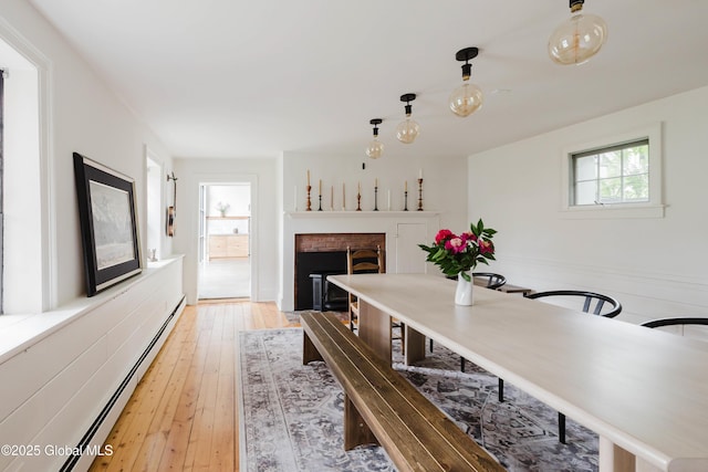 632 Albany Tpke, Chatham, NY 12136 - dining space featuring a baseboard radiator, a fireplace, and light wood-type flooring