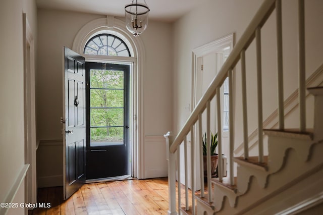 632 Albany Tpke, Chatham, NY 12136 - foyer featuring stairway, light wood finished floors, wainscoting, a decorative wall, and a chandelier