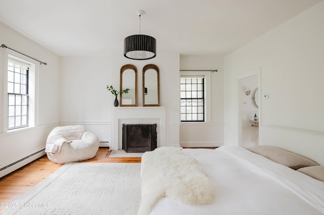 632 Albany Tpke, Chatham, NY 12136 - bedroom featuring wood finished floors, multiple windows, and a baseboard radiator