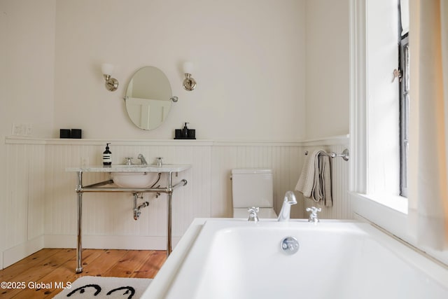 632 Albany Tpke, Chatham, NY 12136 - bathroom with a wainscoted wall, a freestanding tub, wood finished floors, and toilet