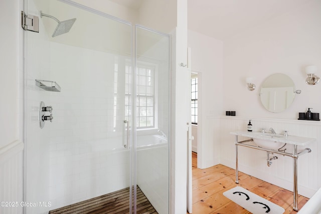 632 Albany Tpke, Chatham, NY 12136 - full bath featuring wood finished floors, a shower stall, and a wainscoted wall