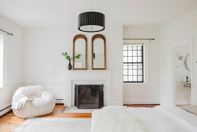 632 Albany Tpke, Chatham, NY 12136 - bedroom featuring wood finished floors, a fireplace, and baseboard heating
