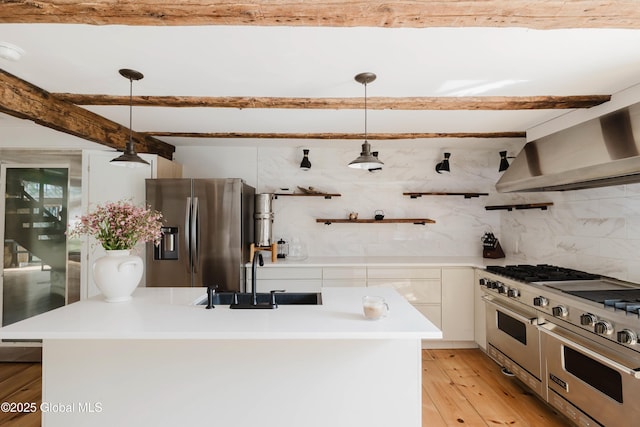 632 Albany Tpke, Chatham, NY 12136 - kitchen with stainless steel appliances, a sink, wall chimney range hood, light wood-style flooring, and hanging light fixtures