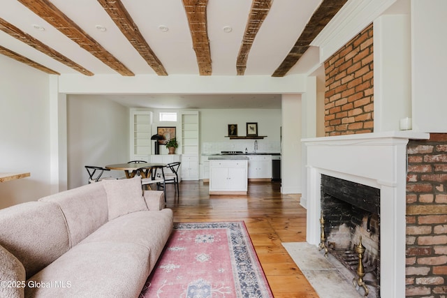 632 Albany Tpke, Chatham, NY 12136 - living area featuring light wood-type flooring, beamed ceiling, and a fireplace with flush hearth