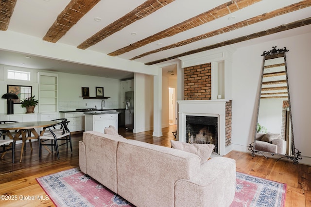 632 Albany Tpke, Chatham, NY 12136 - living area with light wood finished floors, beamed ceiling, a fireplace, and baseboards