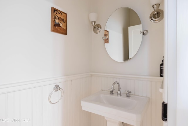 632 Albany Tpke, Chatham, NY 12136 - bathroom featuring a wainscoted wall, a sink, and a decorative wall