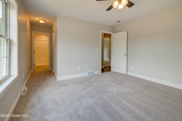 unfurnished bedroom featuring carpet, multiple windows, and baseboards