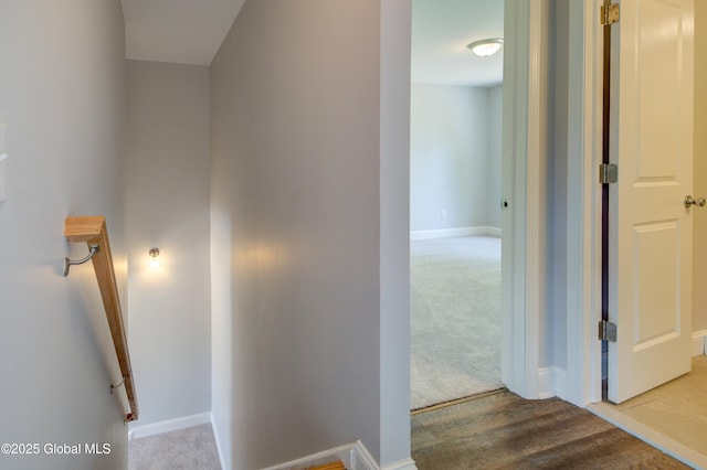 hallway featuring carpet floors and baseboards