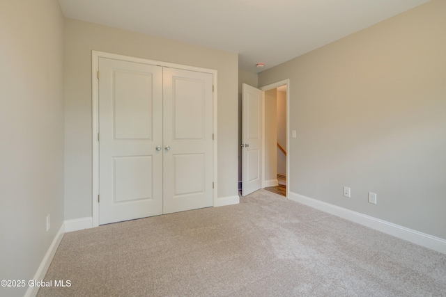 unfurnished bedroom featuring carpet floors, a closet, and baseboards