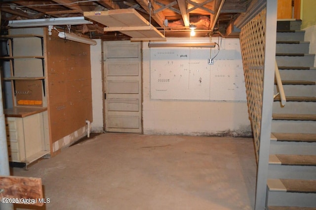unfinished basement featuring stairs