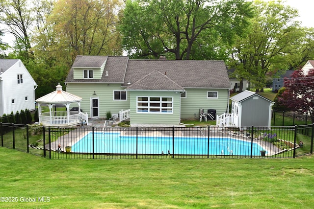 view of swimming pool with a gazebo, an outbuilding, a storage shed, a patio, and view of scattered trees
