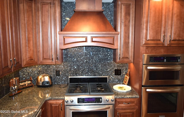 kitchen featuring appliances with stainless steel finishes, premium range hood, tasteful backsplash, and brown cabinetry