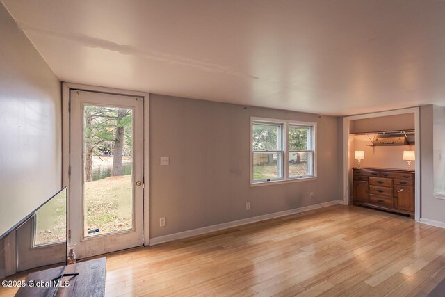5518 Crooked St, Galway, NY 12074 - unfurnished living room featuring light wood-style floors, plenty of natural light, and baseboards