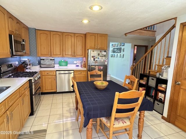 14 Wendom Rd, Albany, NY 12203 - kitchen with appliances with stainless steel finishes, light countertops, brown cabinets, light tile patterned floors, and a textured ceiling