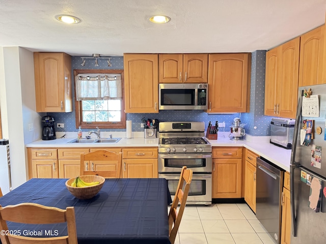 14 Wendom Rd, Albany, NY 12203 - kitchen with appliances with stainless steel finishes, a sink, light countertops, light tile patterned flooring, and wallpapered walls