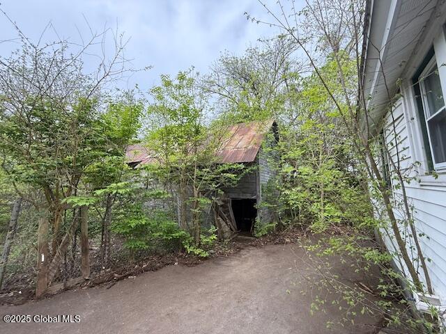 153 River St, Queensbury, NY 12845 - view of home's exterior with a storage unit, an outbuilding, and a patio