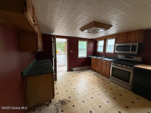 153 River St, Queensbury, NY 12845 - kitchen with stainless steel appliances, a baseboard heating unit, healthy amount of natural light, a sink, and an ornate ceiling